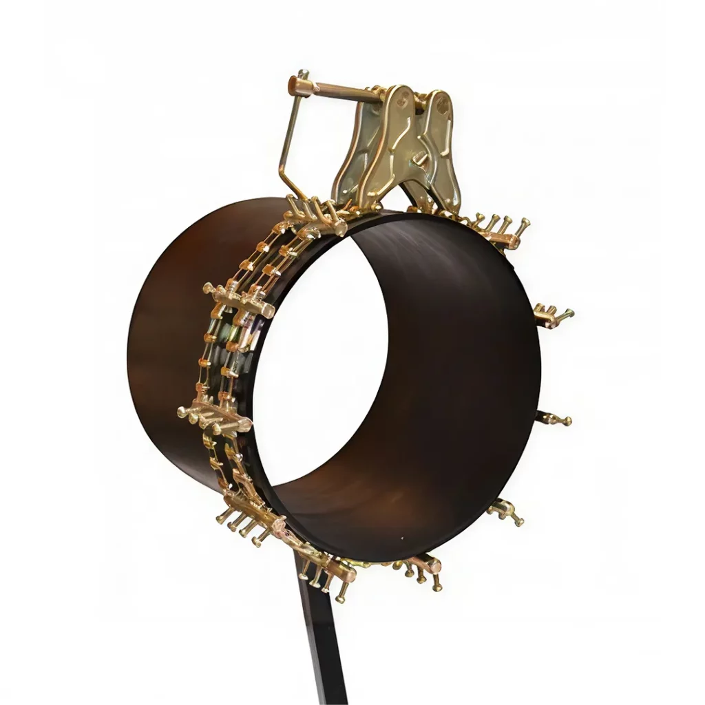 The DK200, a large black cylindrical pipe, is held vertically by a golden metal clamp with adjustable bolts and handles, set against a white background.